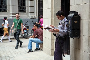 POLICIER LISANT LE JOURNAL DANS LA CALLE OBISPO, SCENE DE RUE, LA HAVANE, CUBA, CARAIBES 
