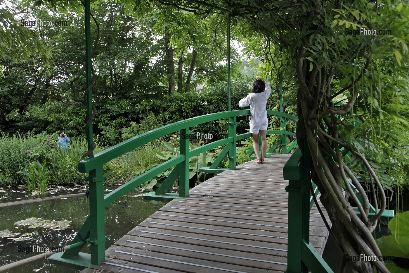 FEMME SUR LE PONT JAPONAIS ET ETANG AUX NYMPHEAS DANS LE JARDIN D'EAU DU PEINTRE IMPRESSIONNISTE CLAUDE MONET, GIVERNY, EURE (27), FRANCE 