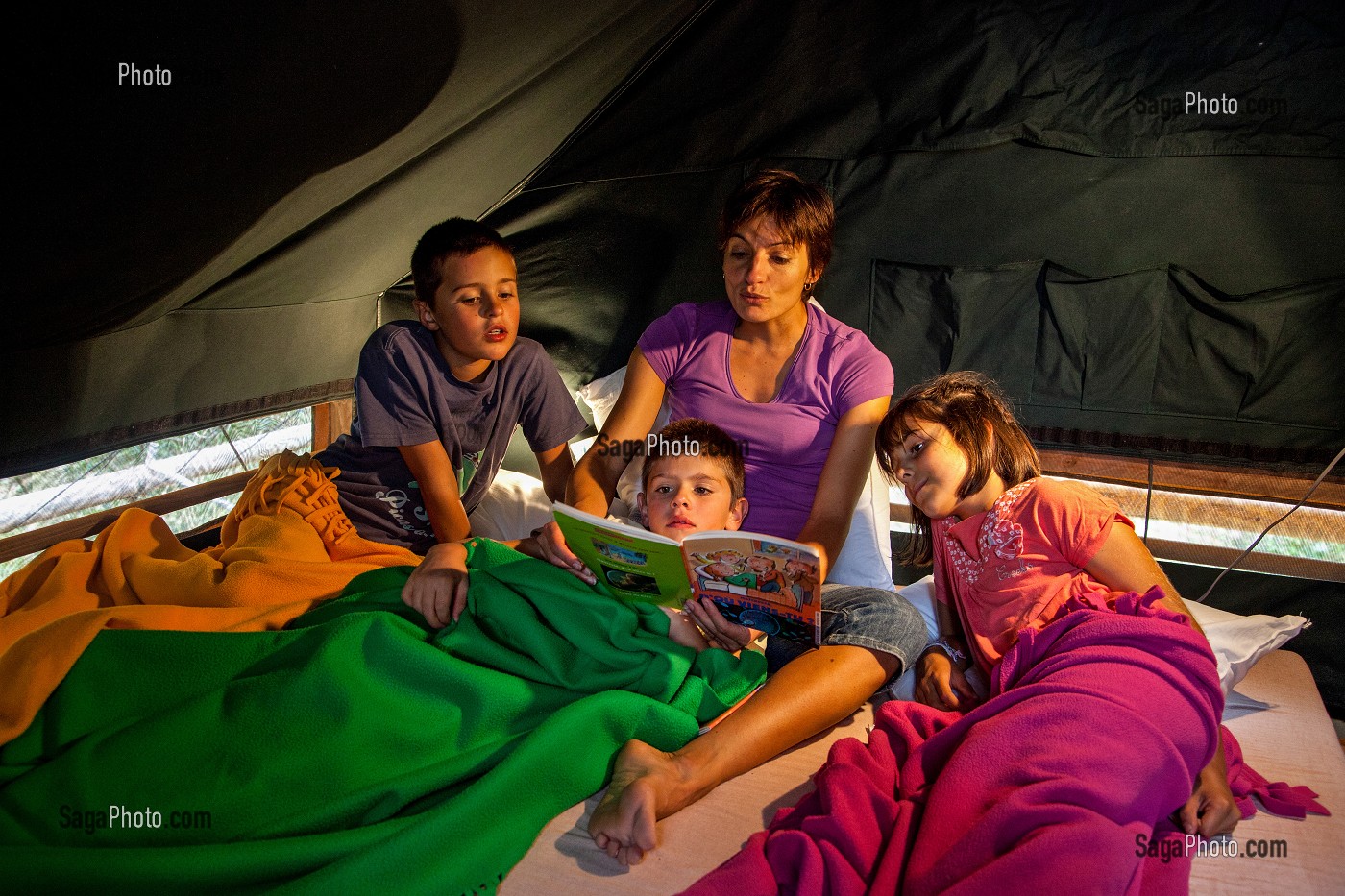 LECTURE D'UNE HISTOIRE AUX ENFANTS AU MOMENT DU COUCHER, VACANCES AU VERT EN FAMILLE AU CAMPEMENT HUTTOPIA, FORET DE SENONCHES, PERCHE, EURE-ET-LOIR (28), CENTRE, FRANCE 