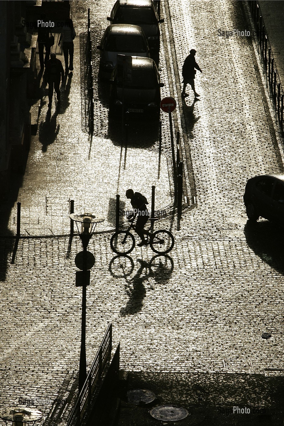 PIETON ET CYCLISTE DANS LA RUE, SCENE DE RUE A CONTRE-JOUR APRES L'AVERSE, VILLE DE TOULOUSE, HAUTE-GARONNE (31), FRANCE 