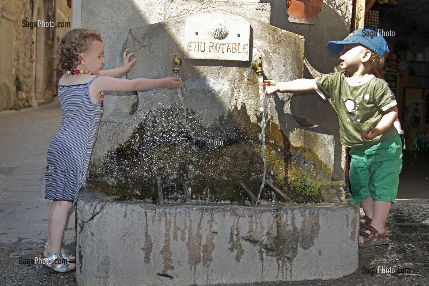 ENFANTS JOUANT AVEC L'EAU D'UNE FONTAINE, SAINT GUILHEM LE DESERT (34), VILLAGE MEDIEVAL, ETAPE DU PELERINAGE DE SAINT JACQUES DE COMPOSTELLE, LABELISE PLUS BEAU VILLAGE DE FRANCE  