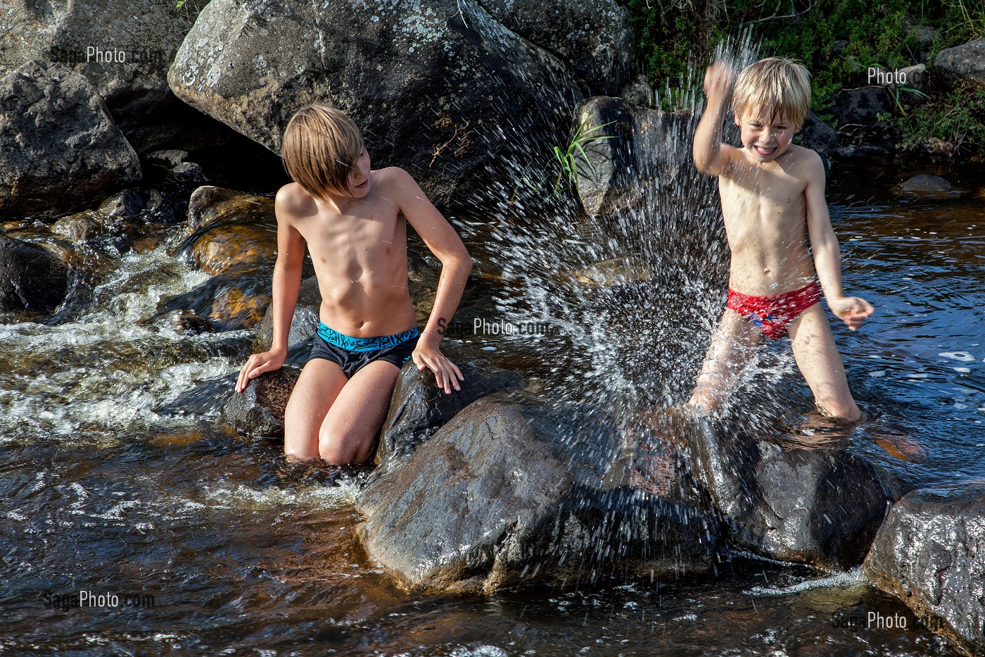ENFANTS JOUANT DANS L'EAU D'UNE RIVIERE, NASBINALS, LOZERE (48), AUBRAC, FRANCE 