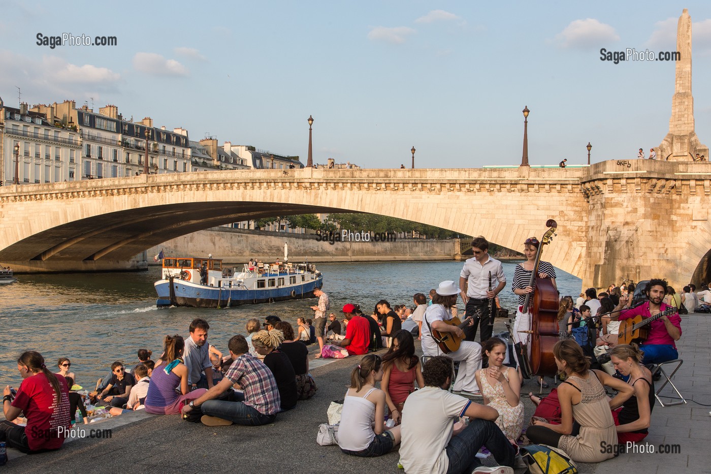 DETENTE DES JEUNES EN BORDS DE SEINE SUR LE QUAI DE LA TOURNELLE, AVEC UNE PENICHE ET PONT DE LA TOURNELLE PARIS (75), FRANCE 