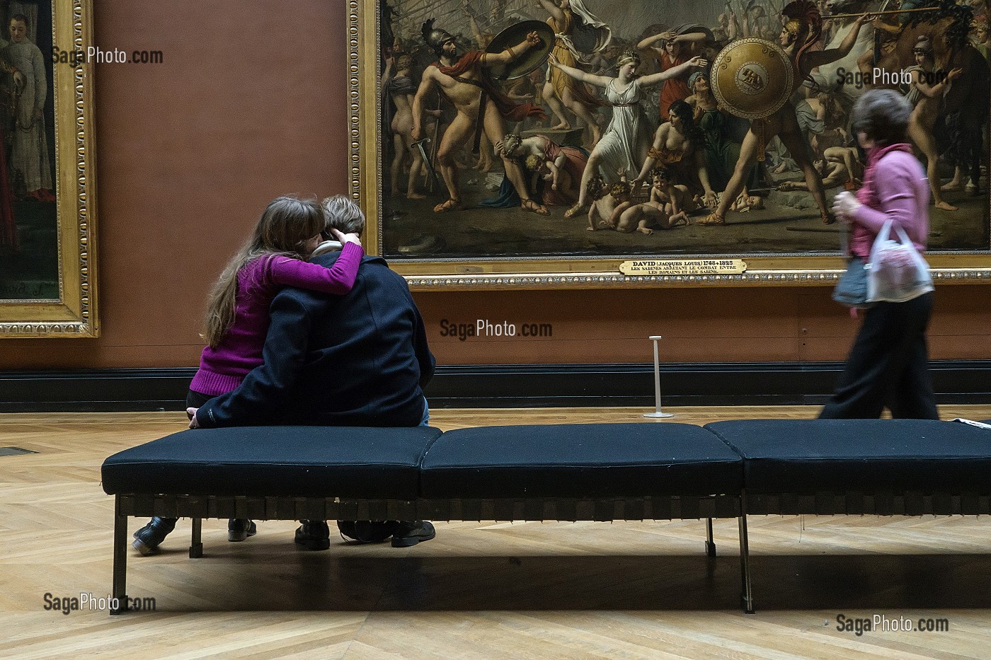 COUPLE DE VISITEURS DEVANT LES SABINES ARRETANT LE COMBAT ENTRE LES ROMAINS ET LES SABINS PAR JACQUES-LOUIS DAVID, SALLE DES PEINTURES FRANCAISES, MUSEE DU LOUVRE, PARIS (75), FRANCE 
