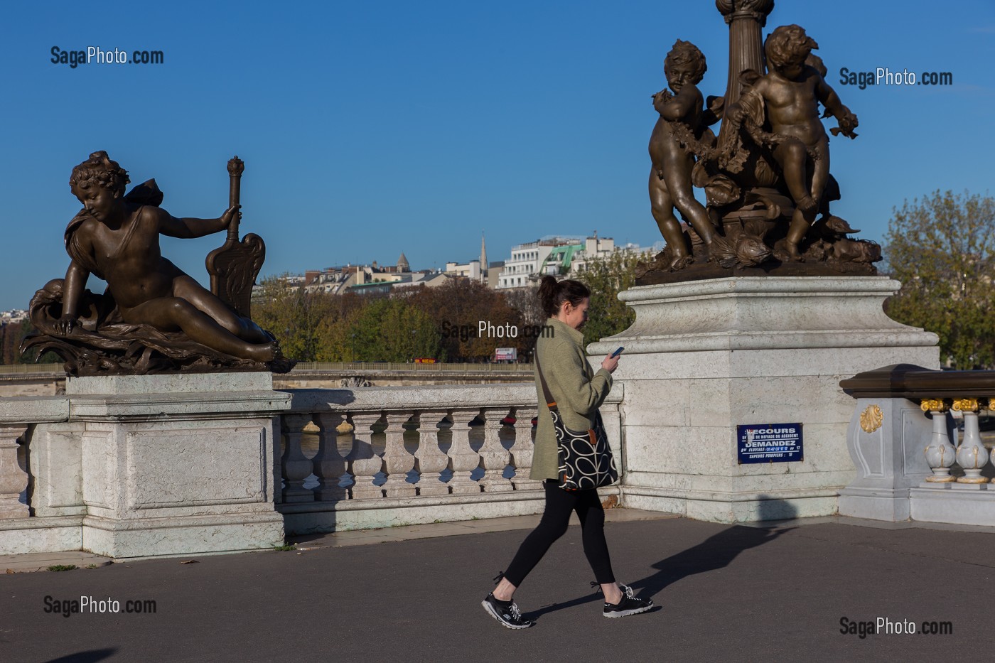 PIETONNE PASSANT DEVANT LA STATUE DE NEREIDE ET LA RONDE D'AMOURS, DETAIL DU PONT ALEXANDRE III QUI RELIE L'ESPLANADE DES INVALIDES A L'AVENUE W. CHURCHILL, IL FUT CONSTRUIT POUR L'EXPOSITION UNIVERSELLE DE 1900, 8 EME ARRONDISSEMENT, PARIS (75), ILE-DE-FRANCE, FRANCE 