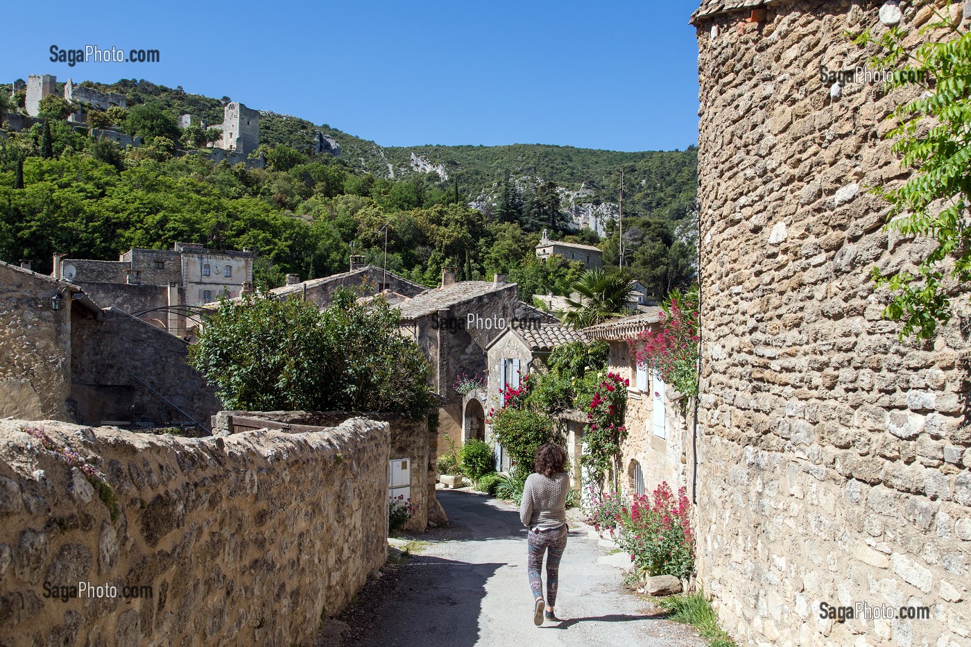 FEMME DANS UNE RUELLE DU VILLAGE ET CHATEAU D'OPPEDE-LE-VIEUX, PARC NATUREL REGIONAL DU LUBERON, VAUCLUSE (84), FRANCE 