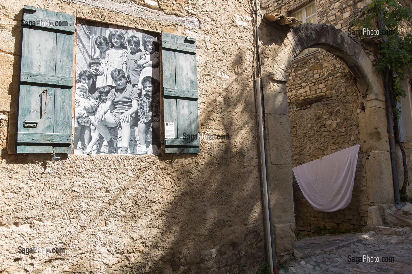 PHOTO HISTORIQUE DANS L'ENCADREMENT D'UNE ANCIENNE FENETRE, DECORATION DANS UNE RUELLE DE LA VILLE HAUTE, VAISON LA ROMAINE, VAUCLUSE (84), FRANCE 