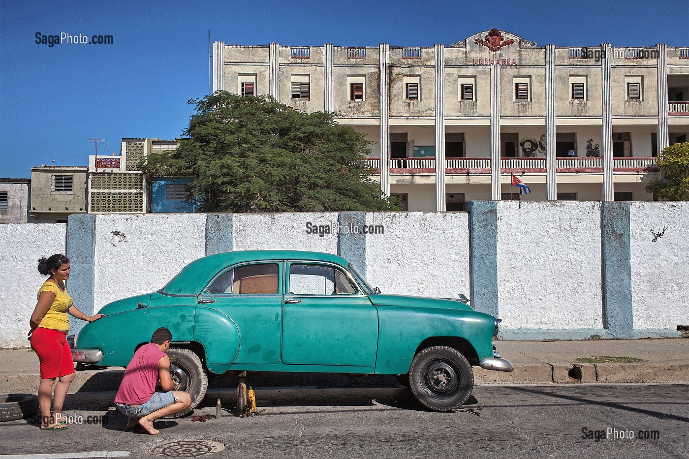 REPARATION D'UNE VIEILLE VOITURE DEVANT UNE ECOLE PRIMAIRE, AMBIANCE DE RUE, CIENFUGOS, ANCIENNE VILLE PORTUAIRE PEUPLEE PAR LES FRANCAIS AU XIX EME SIECLE, CLASSEE AU PATRIMOINE MONDIAL DE L'HUMANITE PAR L'UNESCO, CUBA, CARAIBES 