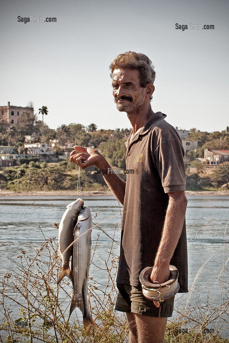 PECHEUR A LA LIGNE AVEC SES POISSONS, COJIMAR, PETIT VILLAGE DE PECHEURS A L'EST DE LA HAVANE OU ERNEST HEMINGWAY AIMAIT PARTIR A LA PECHE EN MER, SOURCE D'INSPIRATION DE SON LIVRE 'LE VIEL HOMME ET LA MER', CUBA, CARAIBES 