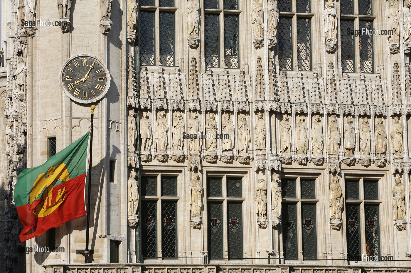 FACADE SCULPTEE ET SES STATUES DE PIERRE, HOTEL DE VILLE ET DRAPEAU AUX COULEURS DE LA VILLE, GRAND PLACE, BRUXELLES, BELGIQUE 