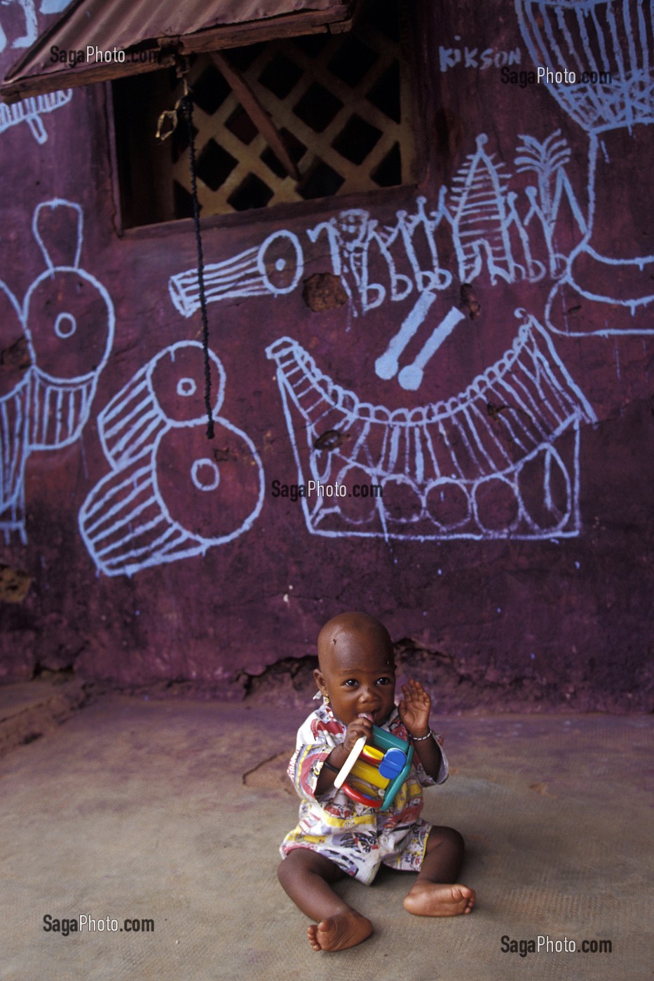 BEBE JOUANT PRES DE SA MAISON A BOBO-DIOULASSO, BURKINA FASO 