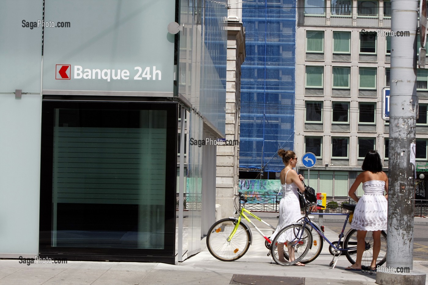 FEMMES A VELO DEVANT UNE BANQUE 24H SUR 24, GENEVE, SUISSE 