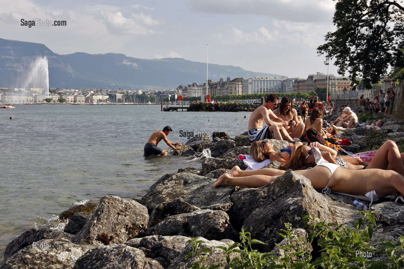 SEANCE DE BRONZAGE SUR LES BORDS DU LAC LEMAN AVEC LE JET D'EAU EN FOND, GENEVE, SUISSE 