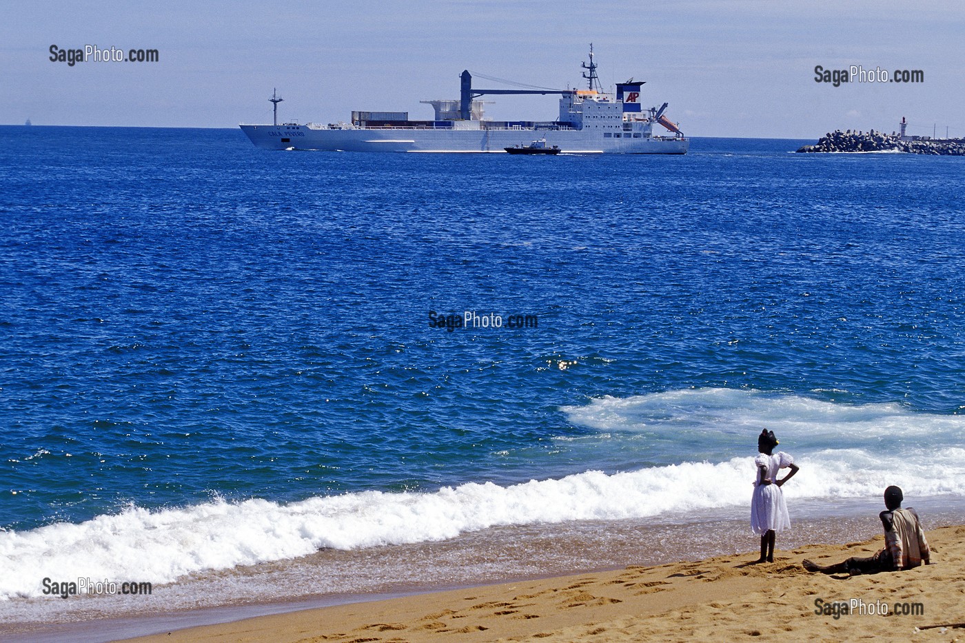 ENFANTS SUR LA PLAGE DEVANT UN NAVIRE DE COMMERCE, ABIDJAN, COTE D'IVOIRE 