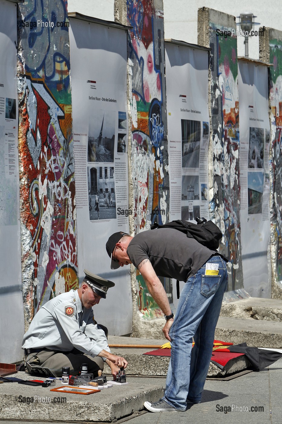 HOMME HABILLE EN MILITAIRE DE L'EX RDA PROPOSE AUX TOURISTES DES TAMPON DE VISA DE LA RDA DEVANT DES FRAGMENTS DU MUR DE BERLIN DE L'EX RDA, BERLIN MAUER, POTSDAMER PLATZ, BERLIN, ALLEMAGNE 