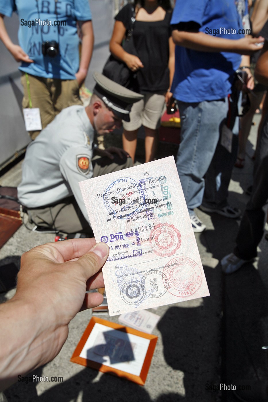 HOMME HABILLE EN MILITAIRE DE L'EX RDA PROPOSE AUX TOURISTES DES TAMPON DE VISA DE LA RDA DEVANT DES FRAGMENTS DU MUR DE BERLIN DE L'EX RDA, BERLIN MAUER, POTSDAMER PLATZ, BERLIN, ALLEMAGNE 