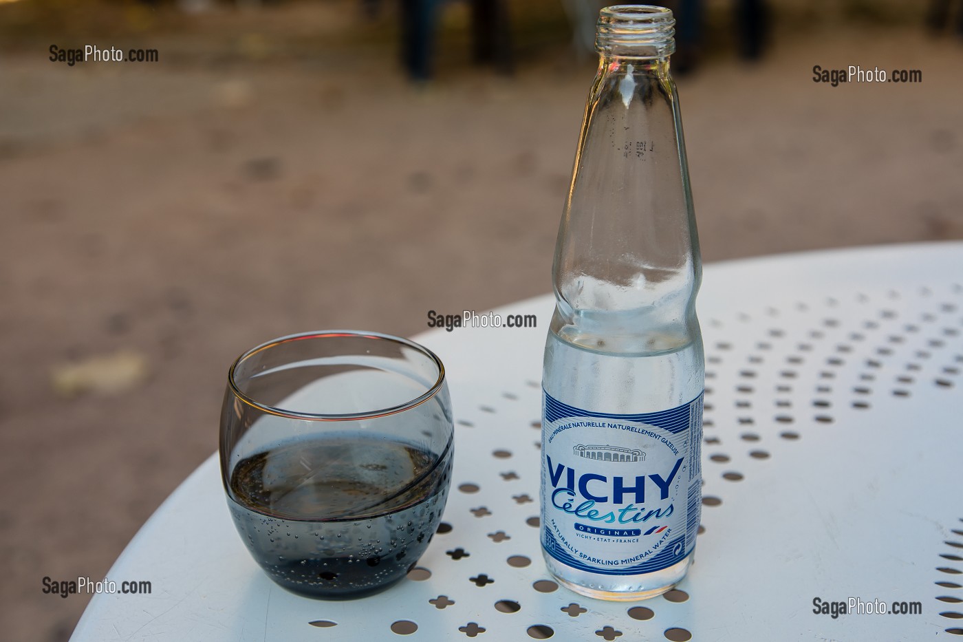 VERRE D'EAU ET BOUTEILLE VICHY CELESTINS SERVIS A LA TERRASSE D'UN CAFE DU PARC DES SOURCES A VICHY, STATION THERMALE, VICHY, ALLIER, REGION AUVERGNE-RHONE-ALPES, FRANCE 