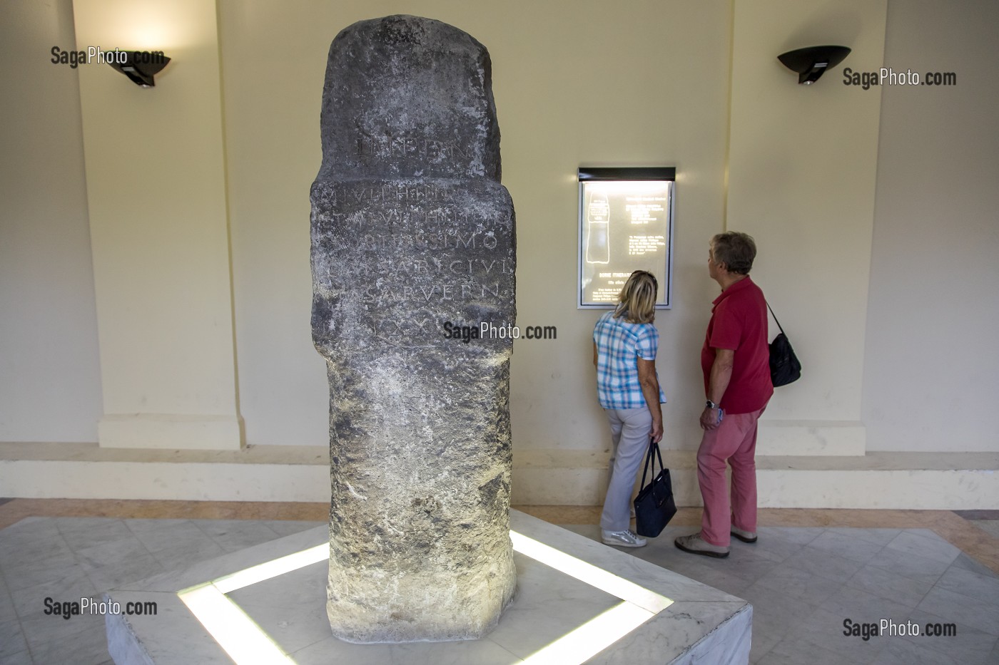 TOURISTES LISANT LES EXPLICATIONS A PROPOS DE LA BORNE MILLIAIRE DE VICHY EXPOSEE DANS LE GRAND HALL DES THERMES CALLOU A VICHY, BORNE GALLO-ROMAINE MARQUANT LA DISTANCE ENTRE AUTUN ET CLERMONT-FERRAND, VICHY, ALLIER, REGION AUVERGNE-RHONE-ALPES, FRANCE 