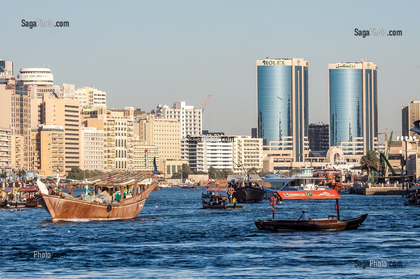 TRAFIC MARITIME AVEC BATEAUX DE COMMERCE ET ABRAS DANS LA CRIQUE DE DUBAI AVEC LES TOURS JUMELLES DE DEIRA EN FOND, DUBAI, GOLFE PERSIQUE, EAU, EMIRATS ARABES UNIS 