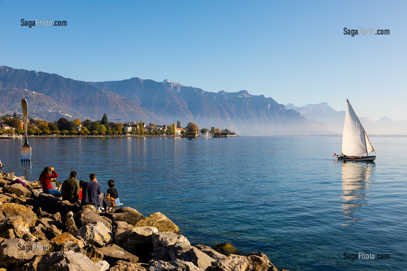 BATEAU VOGUANT SUR LE LAC LEMAN AVEC DES PROMENEURS ET LA FOURCHETTE DE VEVEY, SCULPTURE REALISE PAR L'ARTISTE SUISSE  JEAN-PIERRE ZAUGG, LAC LEMAN, VEVEY, CANTON DE VAUD, SUISSE 