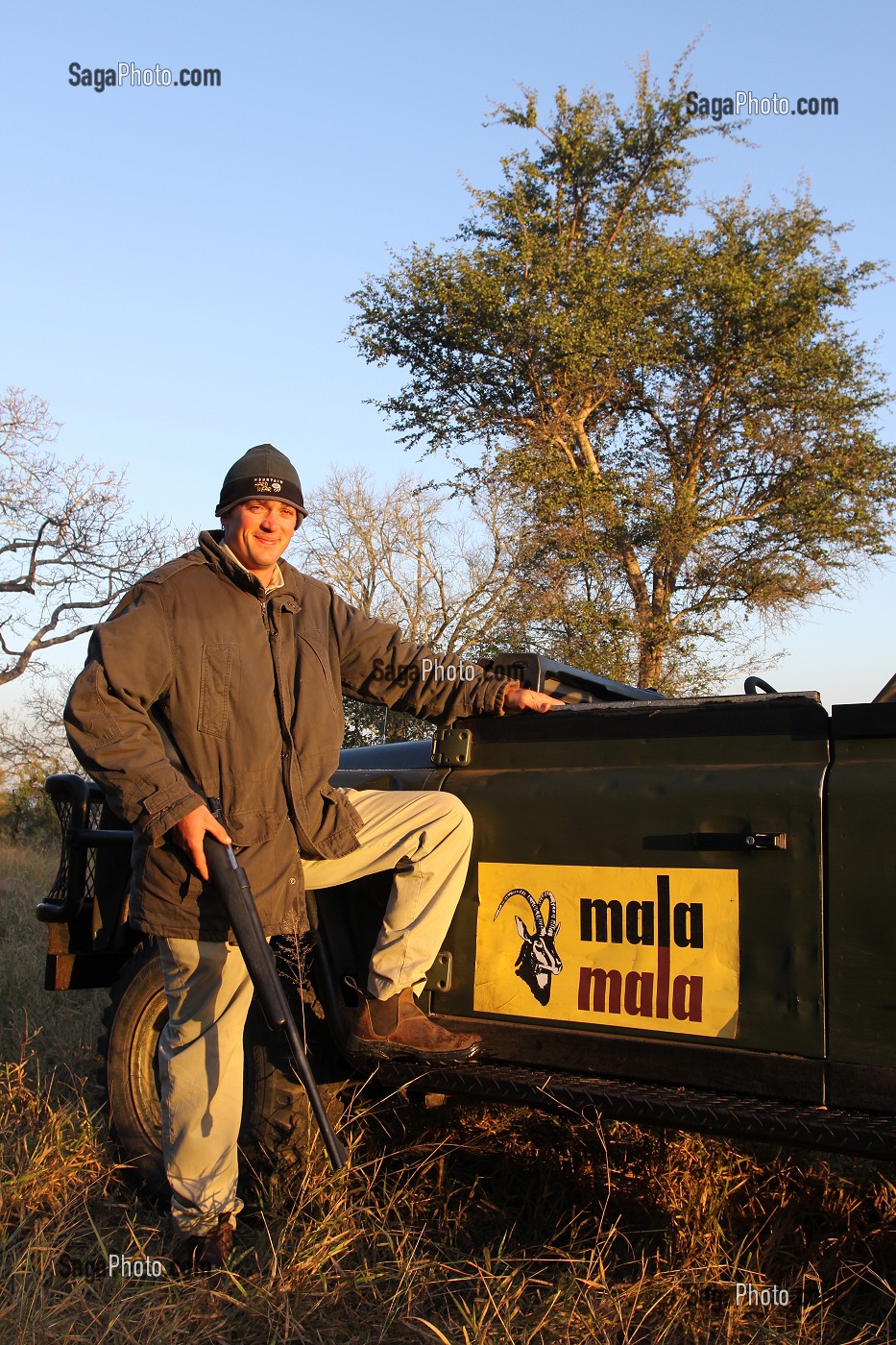 RANGER SUD-AFRICAIN POSANT DEVANT SON 4X4 RANGE ROVER AU LEVER DU SOLEIL, RESERVE PRIVEE DE MALA MALA, RESERVE FAUNIQUE DE SABIE SAND, PARC NATIONAL DU KRUGER, AFRIQUE DU SUD 
