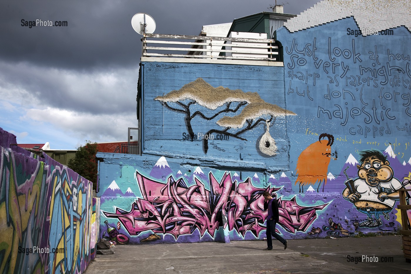 HOMME DEVANT DES MURS ORNES DE GRAFFITI DANS LA CAPITALE REYKJAVIK, ISLANDE, EUROPE 