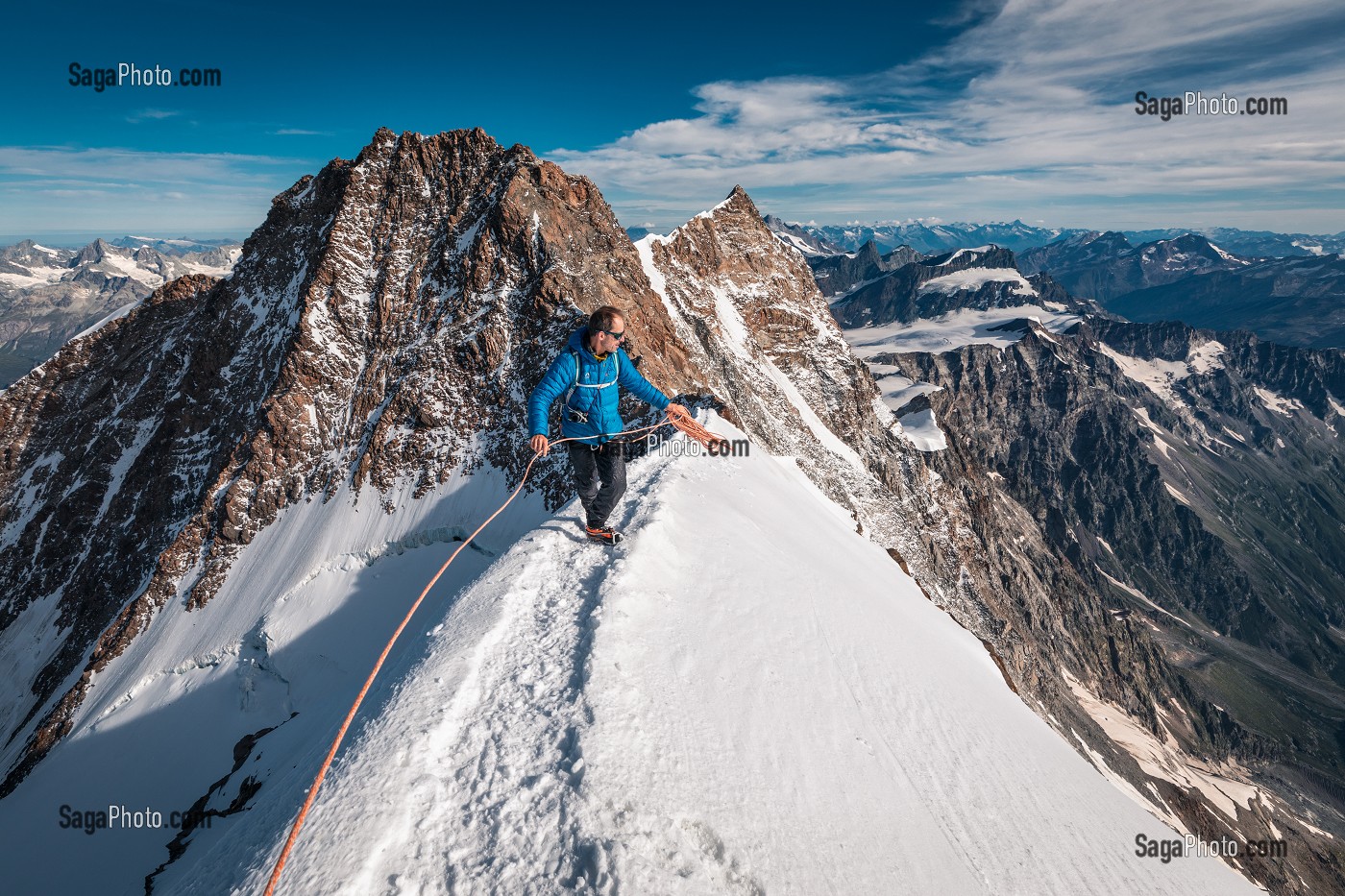 ALPINISTE SUR L'ARETE SOMMITALE DE LA POINTE ZUMSTEIN, POINTE DUFOUR ET MASSIF DU MONT-ROSE EN ARRIERE-PLAN, GRESSONEY-LA-TRINITE, VAL D'AOSTE, ITALIE 