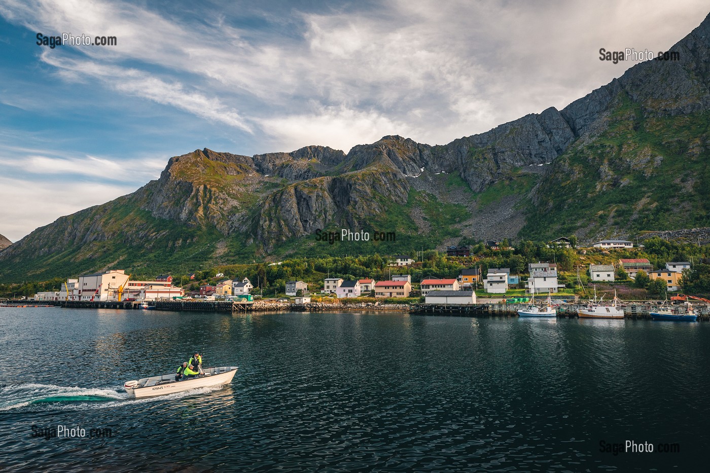 BATEAU DE PECHE RENTRANT DANS LE PORT DE LA VILLE DE GRYLLEFJORD ENTOUREE DE MONTAGNES, SENJA, NORVEGE 