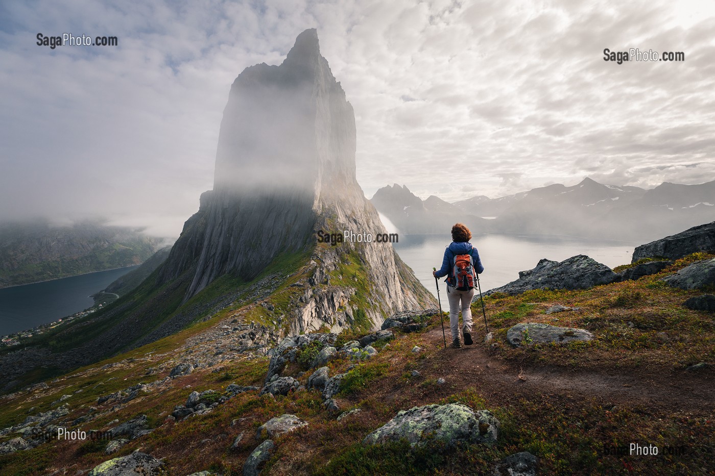 RANDONNEUSE APPROCHANT DES PAROIS DU MONT SEGLA PARTIELLEMENT CACHEES PAR LES NUAGES, FJORDGARD, SENJA, NORVEGE 