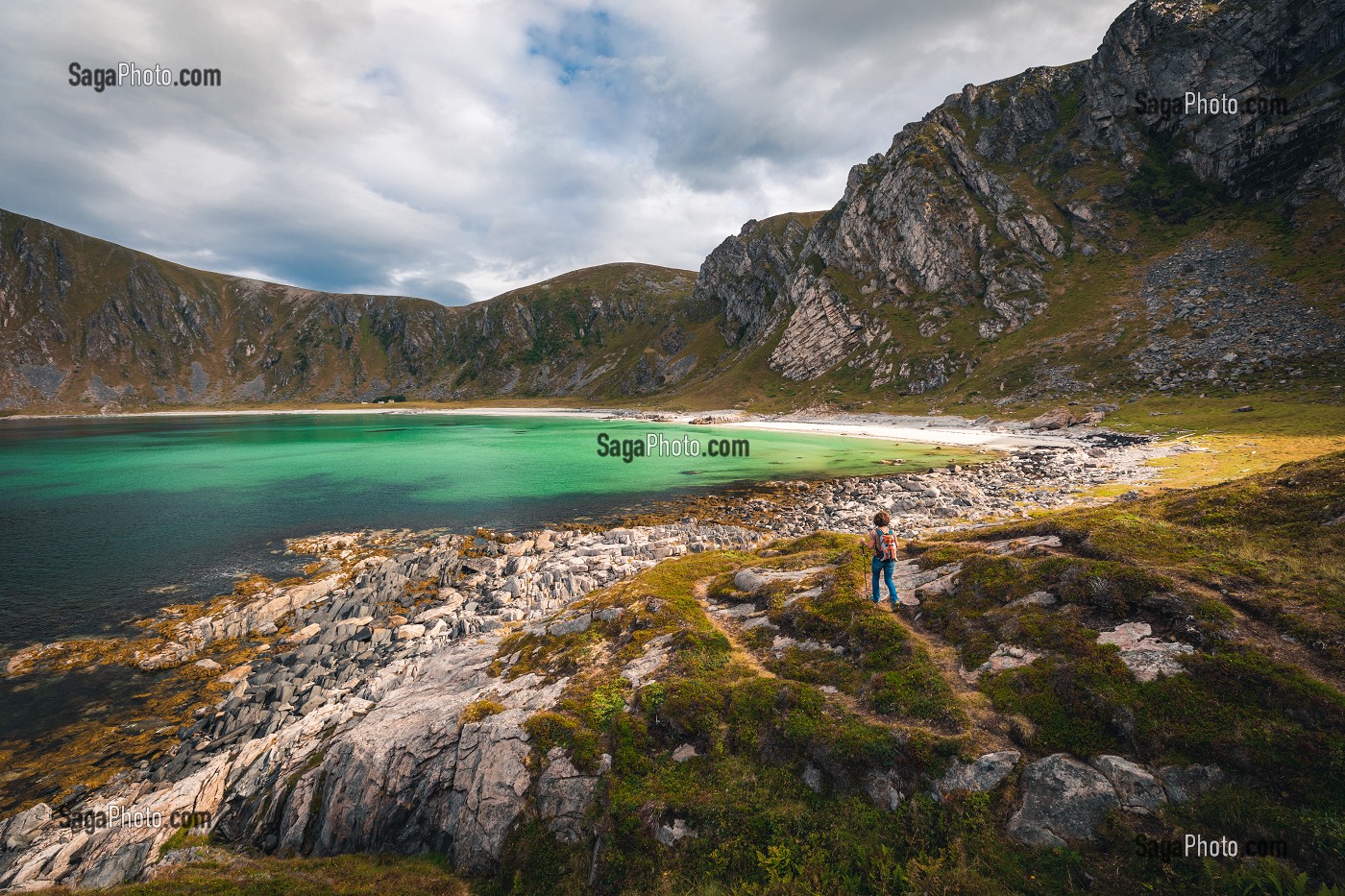 RANDONNEUSE APPROCHANT DE LA PLAGE DE HOYVIKA, SABLE BLANC ET EAU TURQUOISE ENTOURÉS DE MONTAGNES, STAVE, ANDOYA, NORVEGE 