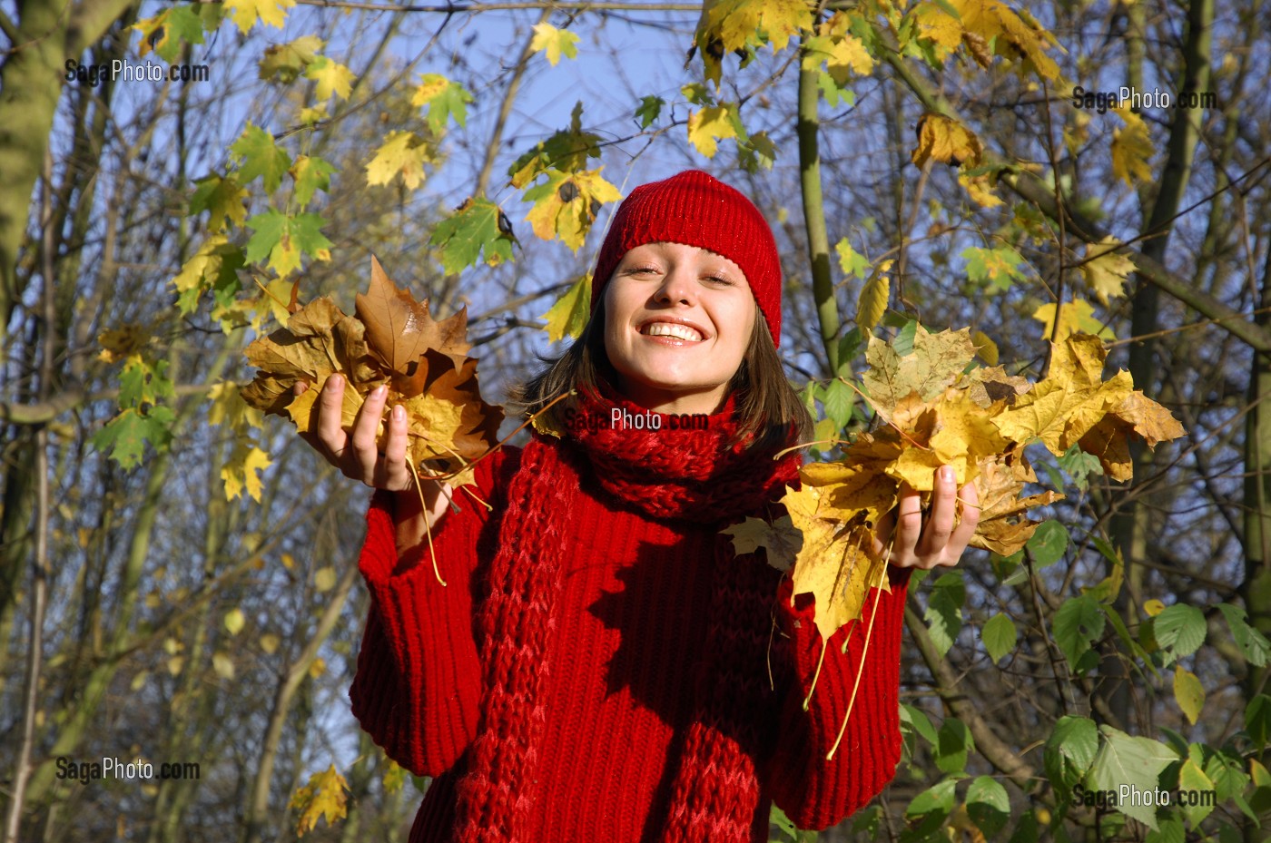 SYMBIOSE AVEC LA NATURE. JEUNE FEMME COUCHEE SUR UN TAPIS DE FEUILLES MORTES EN AUTOMNE 