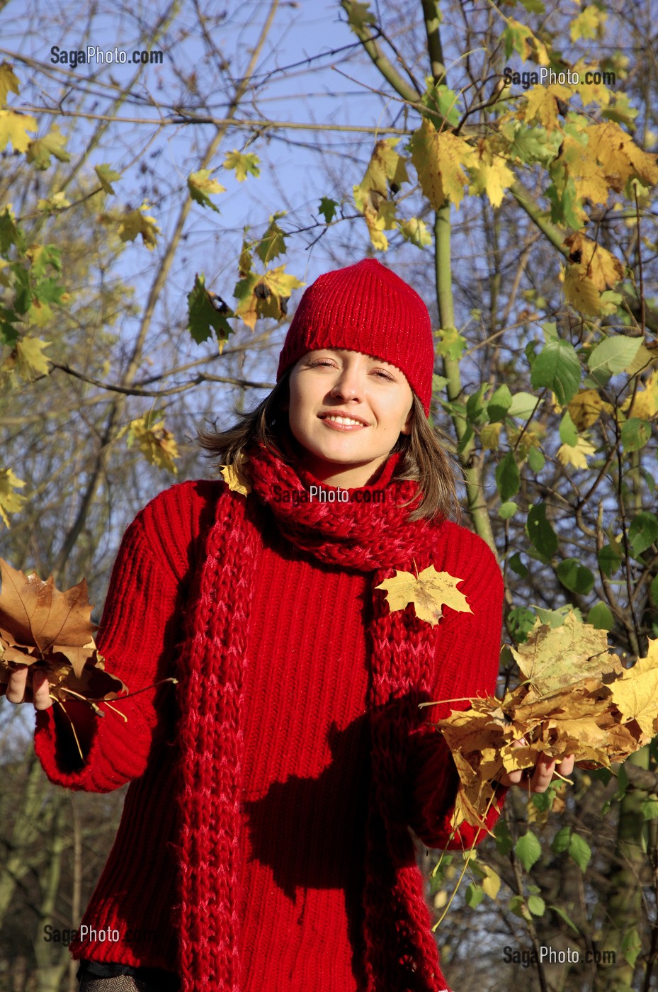 SYMBIOSE AVEC LA NATURE. JEUNE FEMME COUCHEE SUR UN TAPIS DE FEUILLES MORTES EN AUTOMNE 