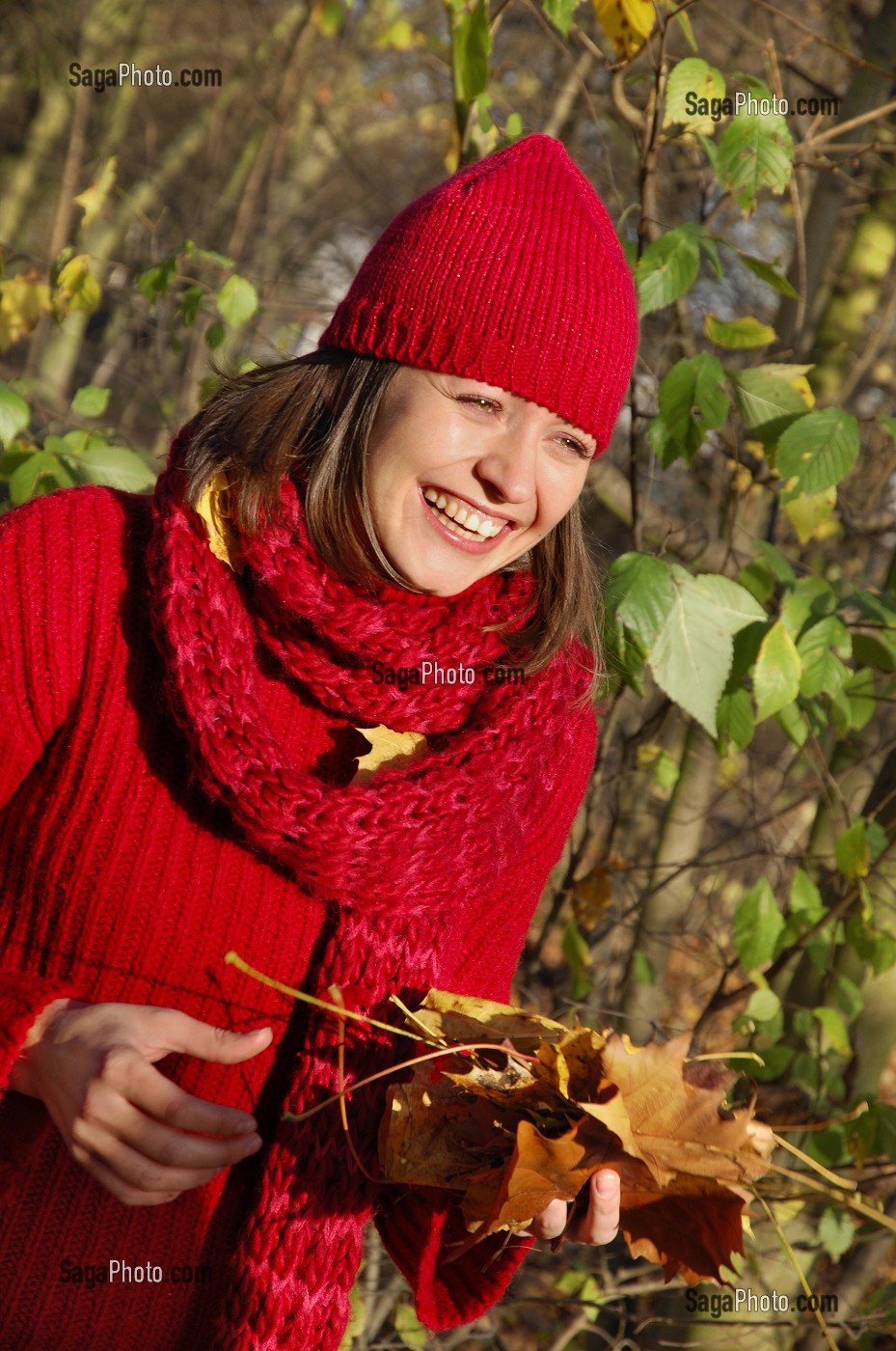 SYMBIOSE AVEC LA NATURE. JEUNE FEMME COUCHEE SUR UN TAPIS DE FEUILLES MORTES EN AUTOMNE 