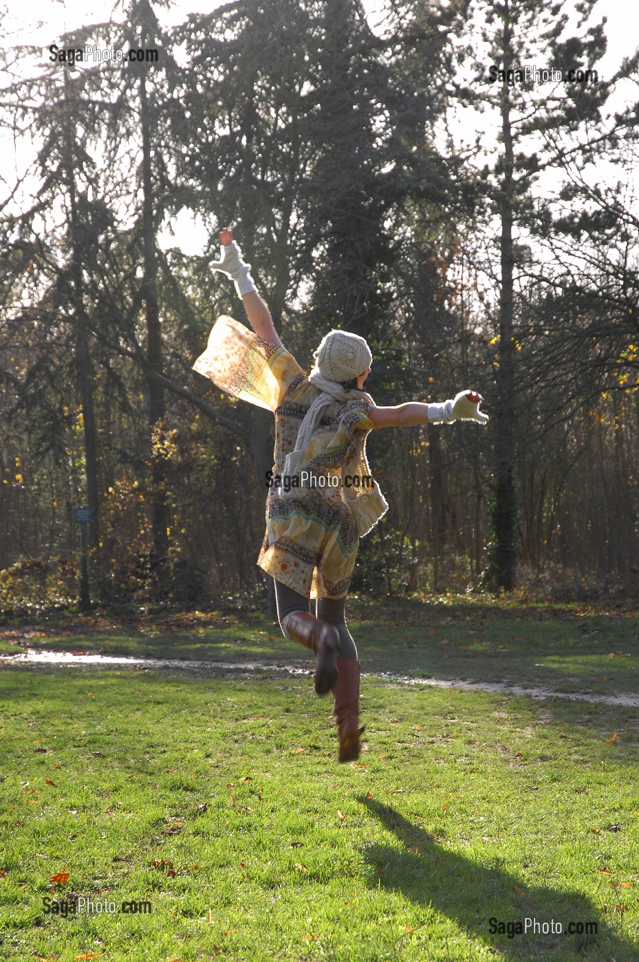 JOIE DE VIVRE ET ENERGIE POSITIVE EN AUTOMNE, SAISON MORNE. JEUNE FEMME DANSANT DANS UNE FORET 