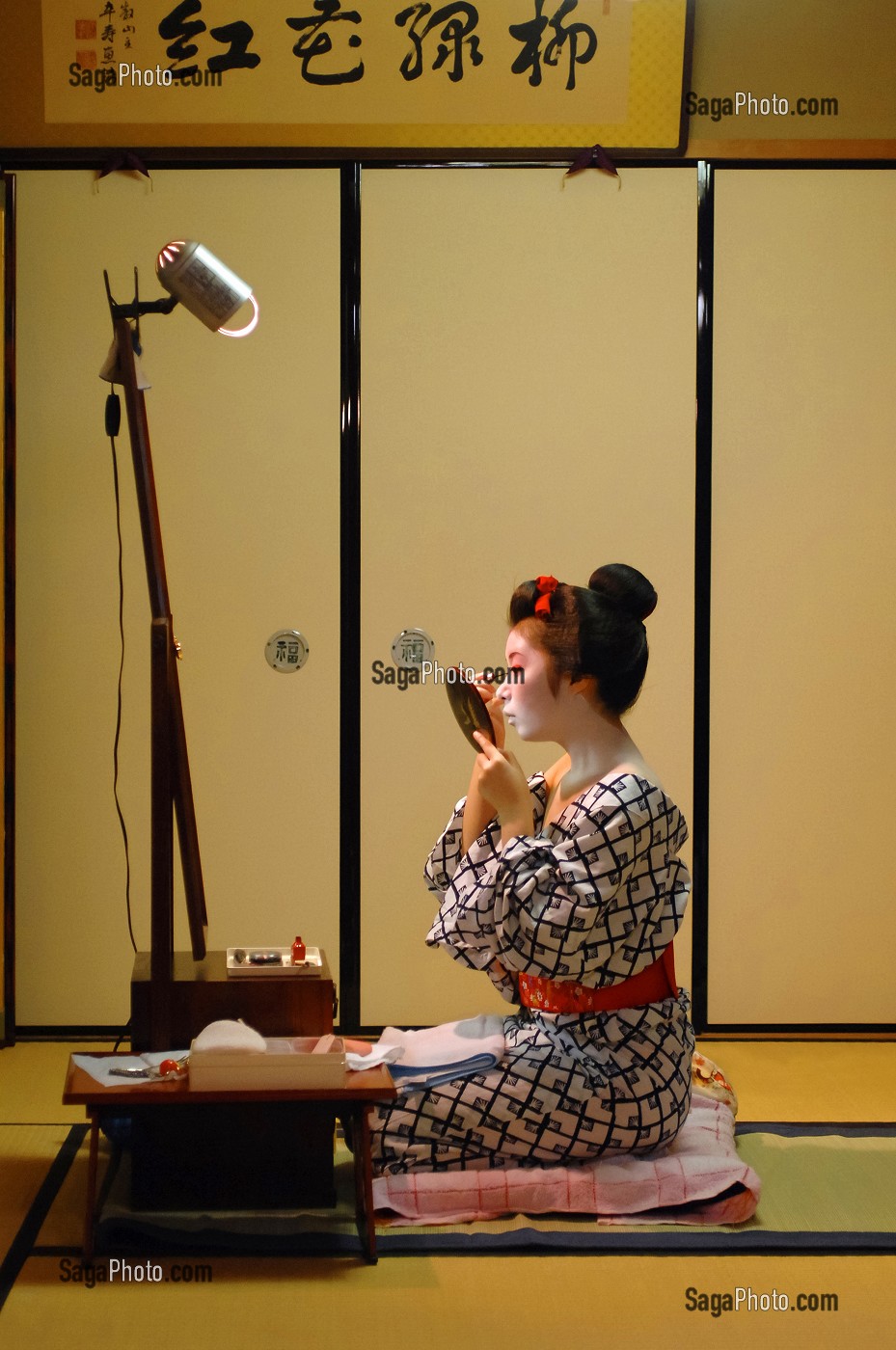 MAQUILLAGE TRADITIONNEL (DORAN) D’UNE MAIKO (APPRENTIE GEISHA), APPLICATION DU FARD BLANC (SHIRONURI) AVEC UN PINCEAU DE BAMBOU (BURASHI), LA MAIKO A UN CHIGNON EN FORME DE PECHE FENDUE (WARESHINOBU) ORNE DE RUBANS ROUGES EN SOIE (KANOKO) ET PORTE UN KIMONO DE COTON (YUKATA), QUARTIER DE GION, KYOTO, JAPON, ASIE 