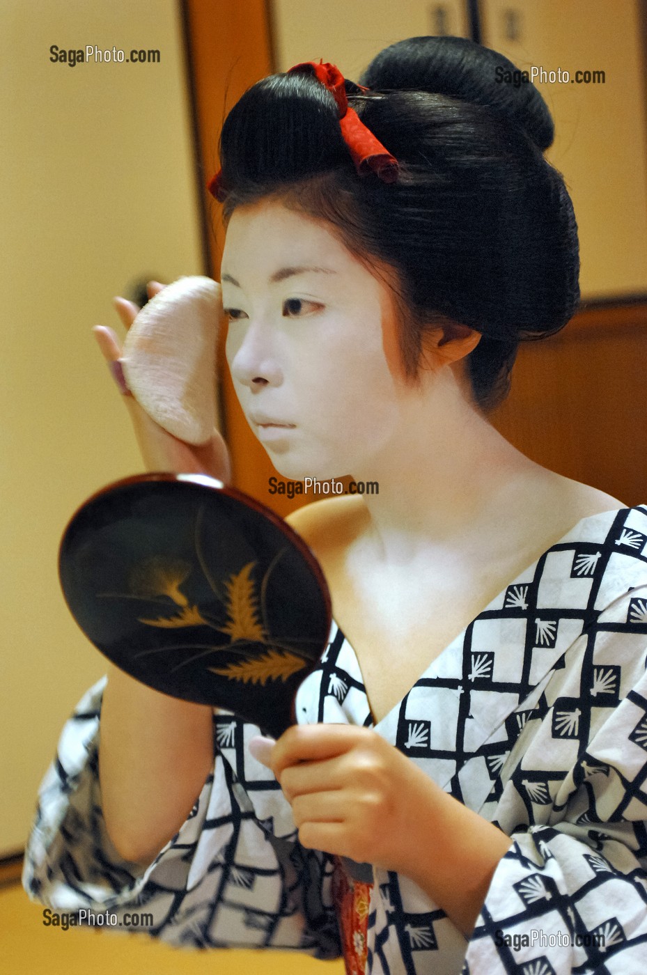 MAQUILLAGE TRADITIONNEL (DORAN) D’UNE MAIKO (APPRENTIE GEISHA), APPLICATION SUR LE VISAGE DE POUDRE DE RIZ AVEC UNE EPONGE (KONYAKU) SUR LE FARD BLANC (SHIRONURI), LA MAIKO A UN CHIGNON EN FORME DE PECHE FENDUE (WARESHINOBU) ORNE DE RUBANS ROUGES EN SOIE (KANOKO) ET PORTE UN KIMONO DE COTON (YUKATA), QUARTIER DE GION, KYOTO, JAPON, ASIE 