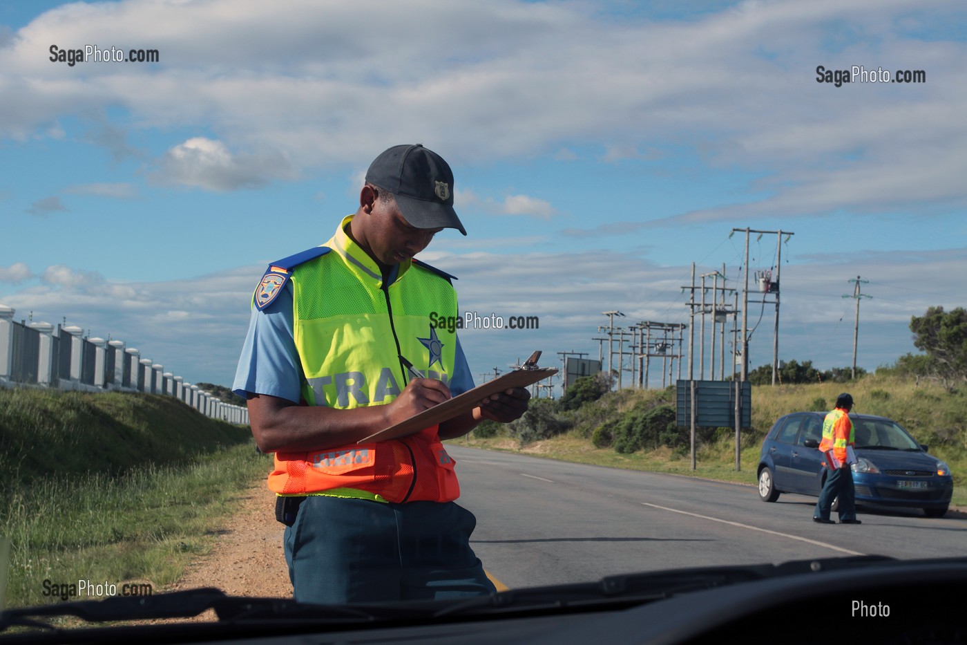 POLICIER NOTANT LA PLAQUE D'IMMATRICULATION DU VEHICULE LORS D'UN CONTROLE ROUTIER A LA SORTIE DE LA VILLE DE SAINT-FRANCIS, ROUTE DES JARDINS, PROVINCE DU CAP OCCIDENTAL, AFRIQUE DU SUD 