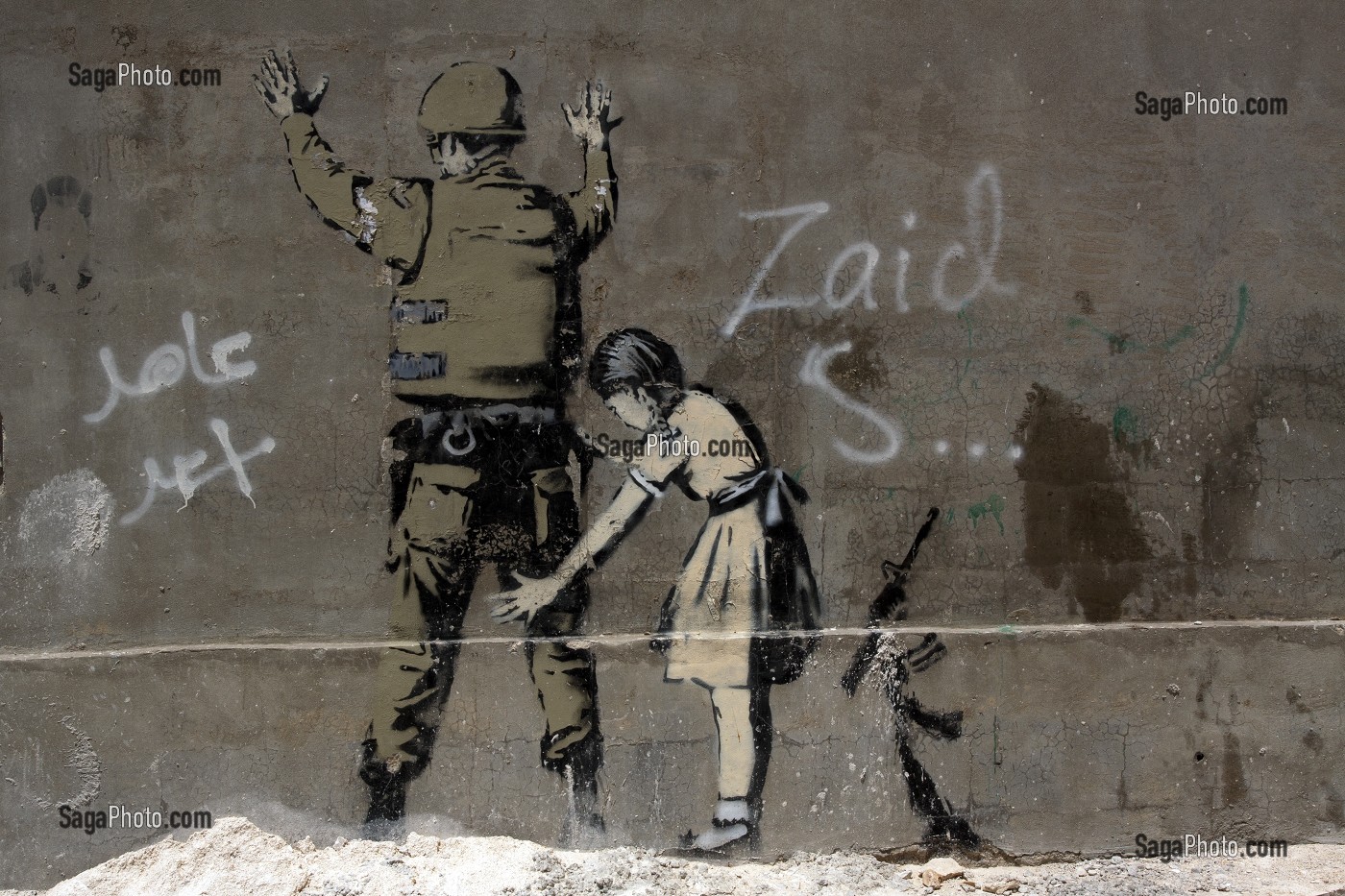 JEUNE FILLE FOUILLANT UN SOLDAT, DESSIN DU GRAFFEUR BRITANNIQUE BANKSY SUR UN MUR DE LA VILLE, BETHLEEM, CISJORDANIE, AUTORITE PALESTINIENNE 