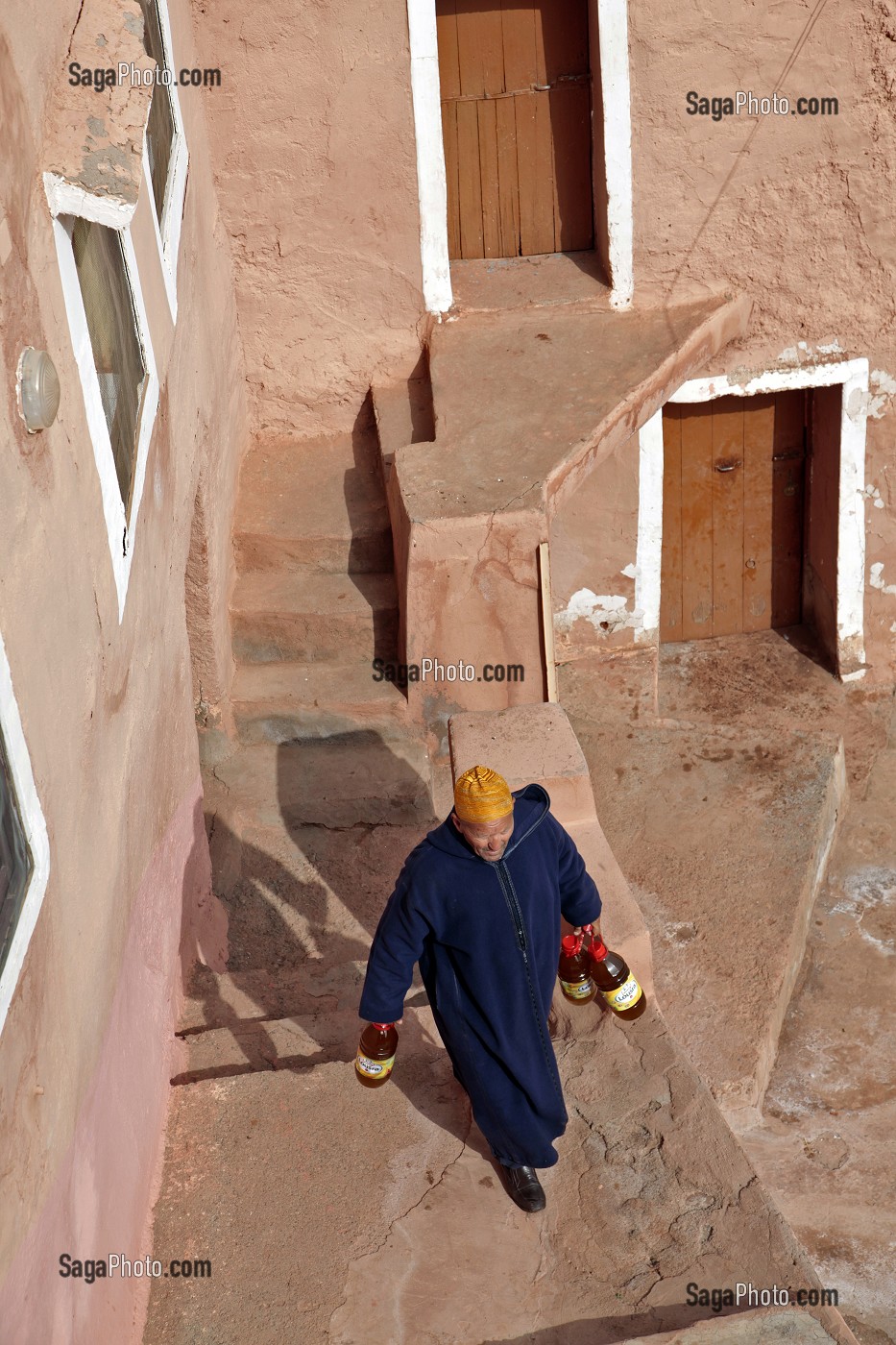 CHEF DU VILLAGE DE IGLI PORTANT DES BOUTEILLE D'HUILE DE SA PRODUCTION, AL HAOUZ, MAROC 