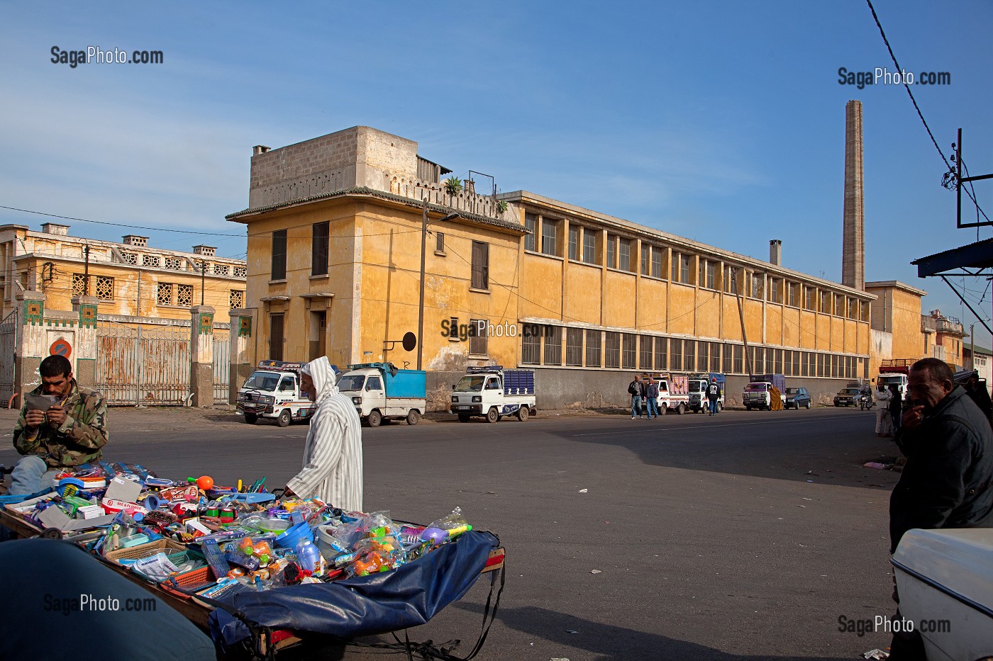 COMMERCANT AMBULANT DEVANT LE SITE DESAFFECTE DES ABATTOIRS DE CASABLANCA, FRICHE URBAINE EN BETON ARME, HERITAGE DU MARECHAL LYAUTEY, MAROC 