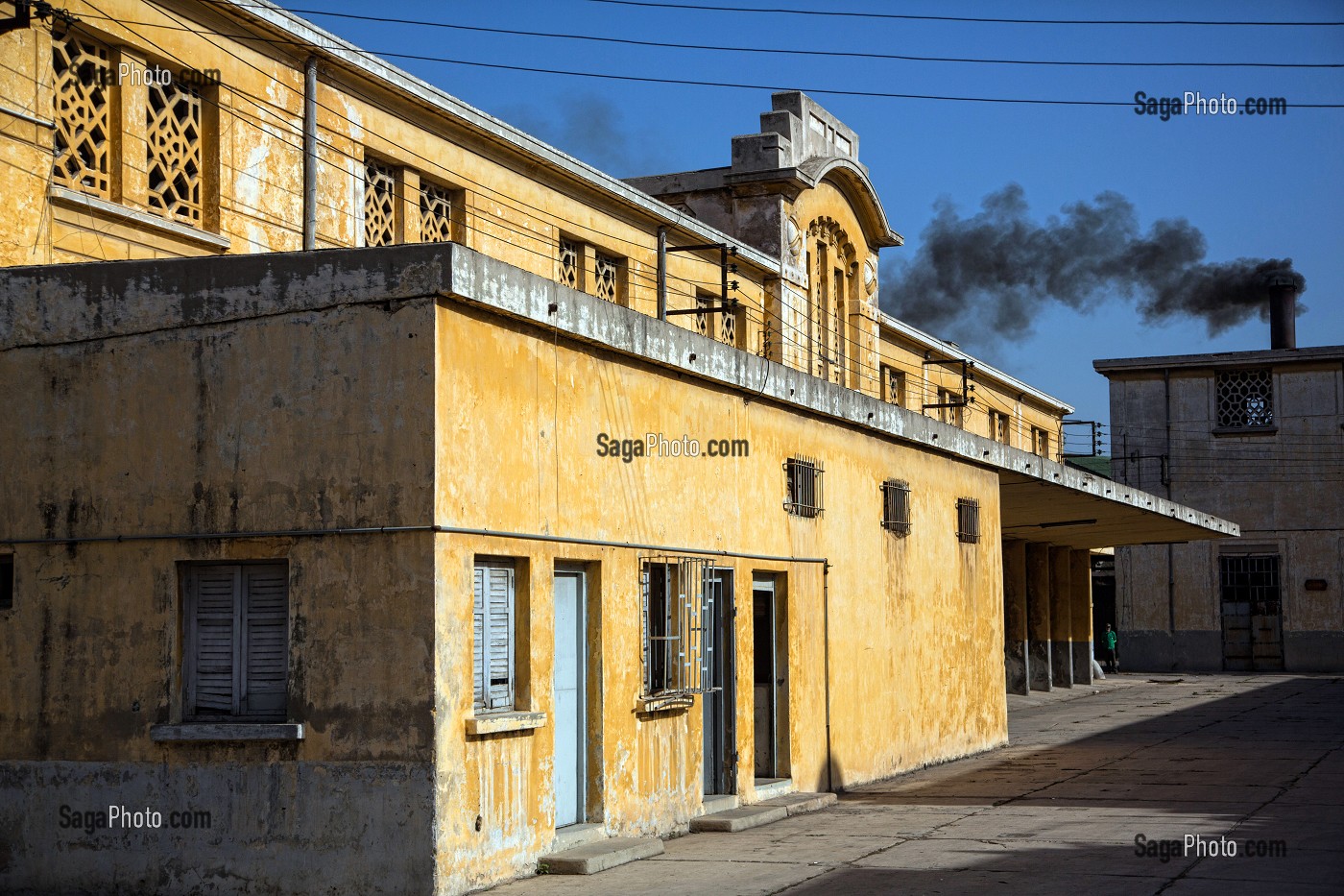 FACADE D'UN BATIMENT ET CHEMINEE AVEC DE LA FUMEE NOIRE DANS ANCIENS ABATTOIRS, ARCHITECTURE EN BETON ARME, HERITAGE DU MARECHAL LYAUTEY, CASABLANCA, MAROC, AFRIQUE 