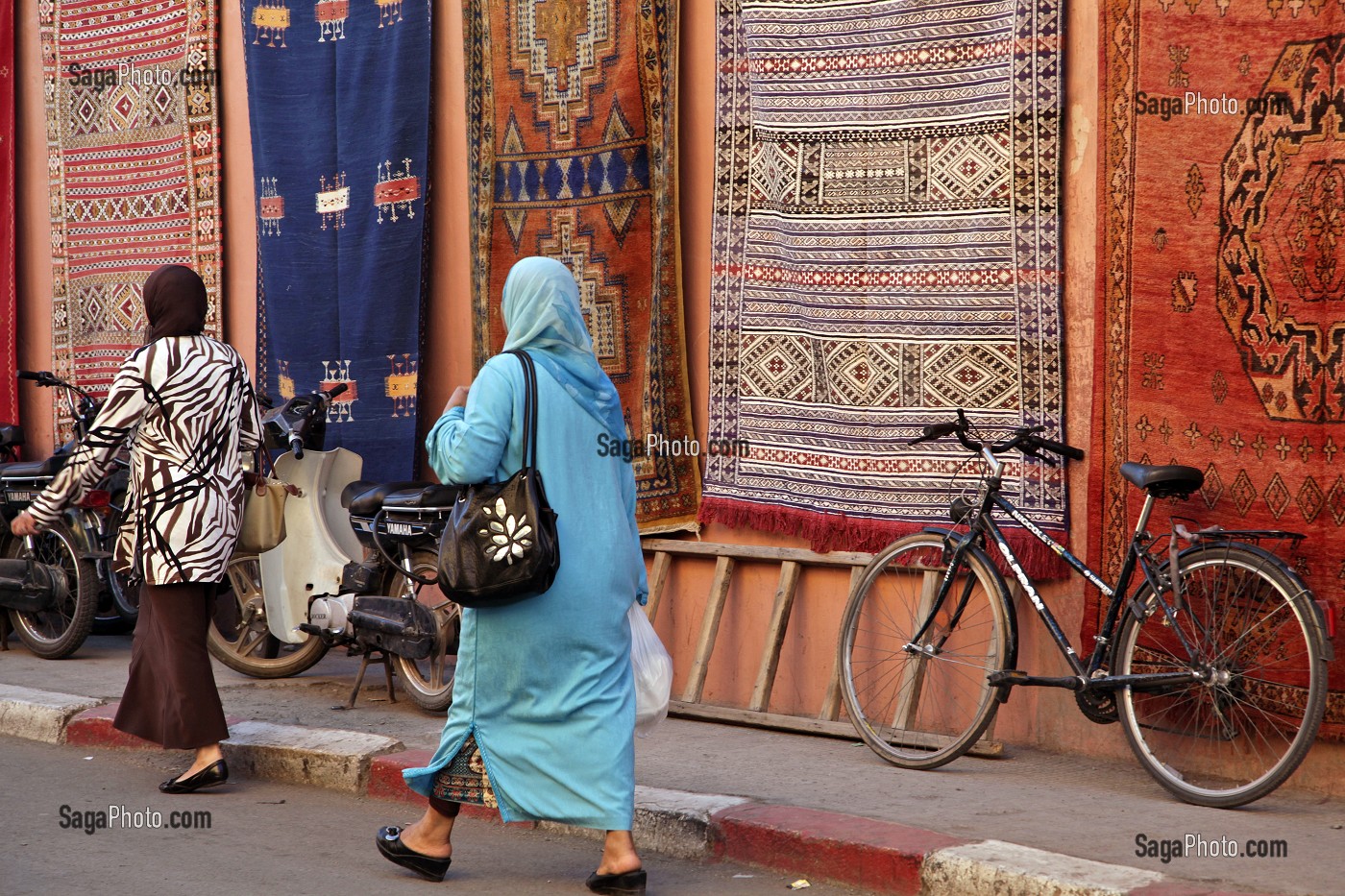 FEMMES VOILEES PASSANT DEVANT DES TAPIS BERBERES, ENTREE DU SOUK (MARCHE AUX TAPIS), AU COEUR DE LA MEDINA, MARRAKECH, MAROC 