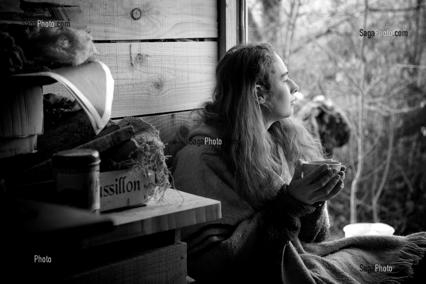 LORELEI BOIT SON BOL DE THE AU PETIT MATIN A L'ENTREE DE SA CABANE, ELLE A TOUT QUITTE POUR CONSTRUIRE ET HABITER SA CABANE EN BOIS AU MILIEU DE LA CREUSE, FRANCE 