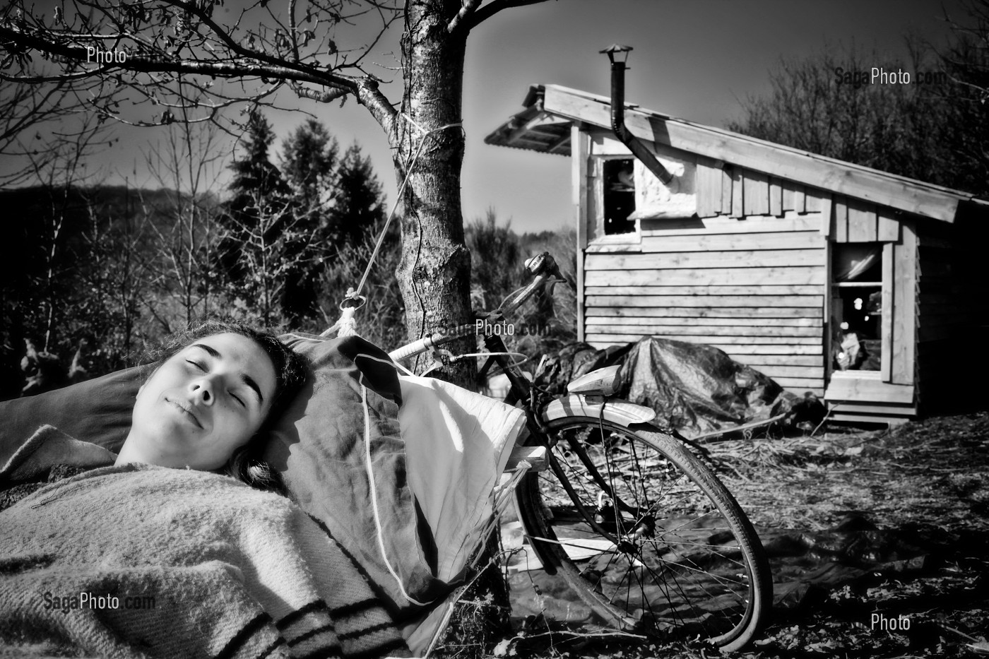 LORELEI FAIT LA SIESTE DANS SON HAMAC, ELLE A TOUT QUITTE POUR CONSTRUIRE ET HABITER SA CABANE EN BOIS AU MILIEU DE LA CREUSE, FRANCE 