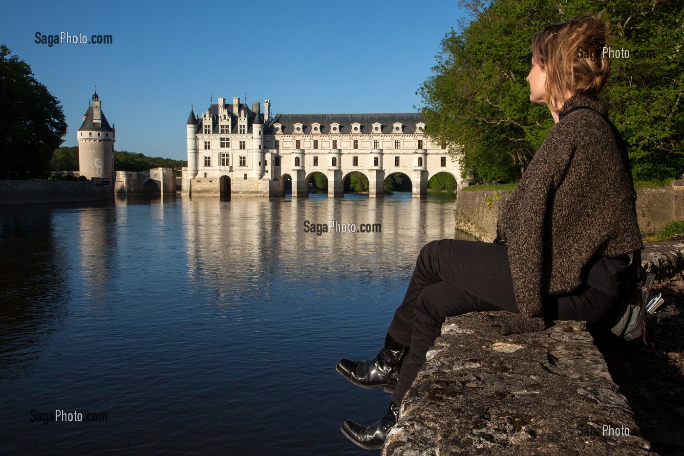 FEMME ASSISE DEVANT LE CHATEAU DE CHENONCEAU POSE SUR LES RIVES DU CHER, INDRE-ET-LOIRE (37), FRANCE 