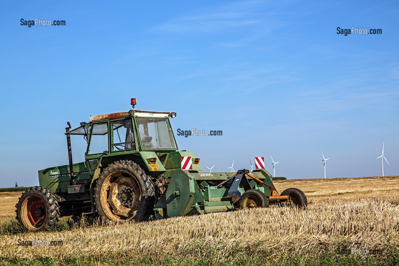 TRACTEUR AU TRAVAIL DE LA TERRE DEVANT DES EOLIENNES, EURE-ET-LOIR (28), FRANCE 