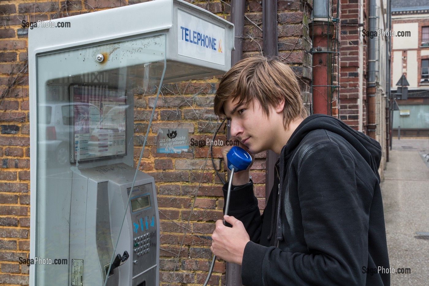ADOLESCENT TELEPHONE DANS UNE CABINE TELEPHONIQUE DE FRANCE TELECOM, RUGLES,  (27) EURE, FRANCE 