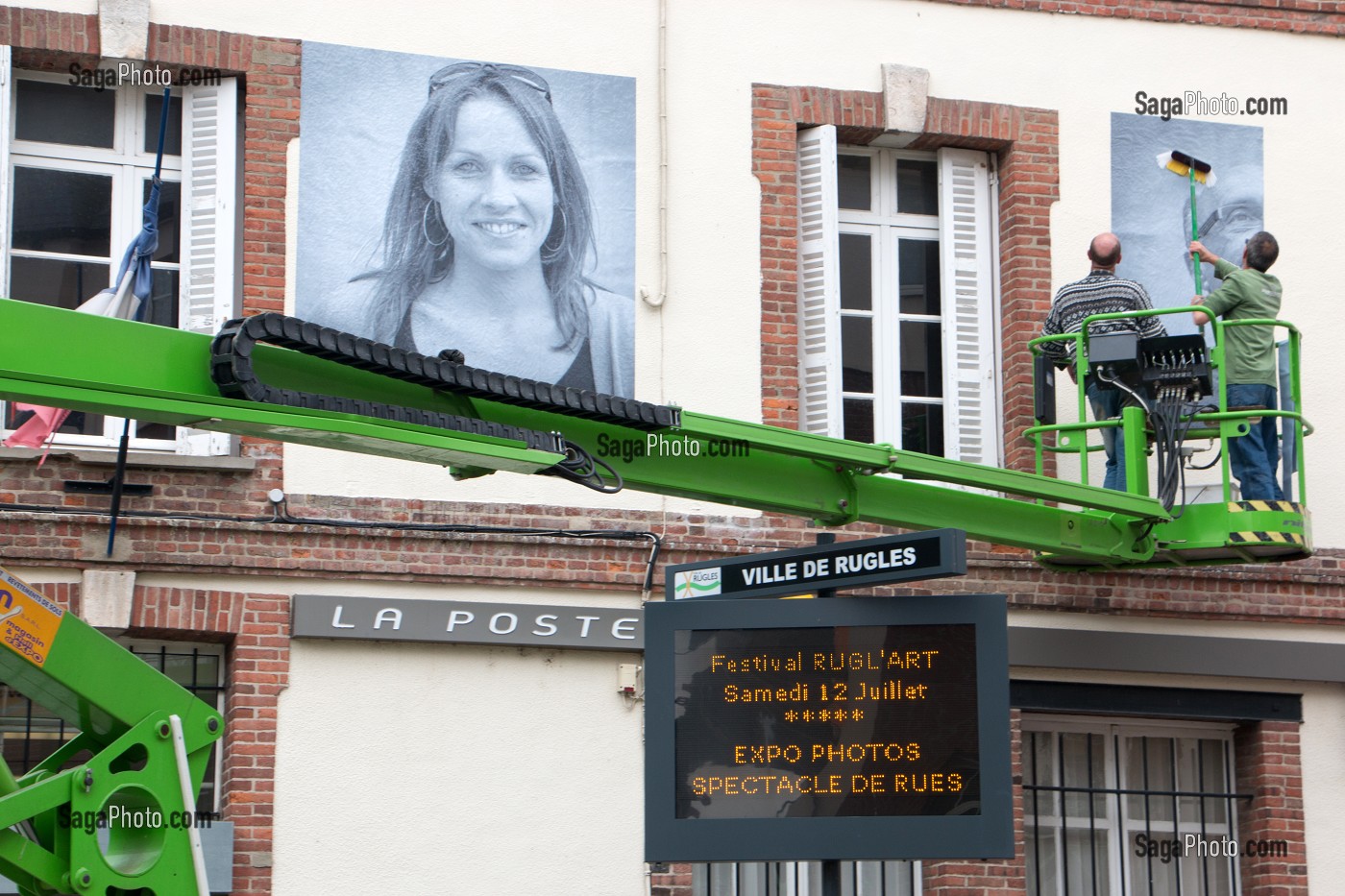 COLLAGE AVEC UNE NACELLE DES PHOTOS GEANTES SUR LES MURS (LA POSTE) DE LA VILLE POUR LE FESTIVAL CULTUREL RUGL'ART, RUGLES, (27) EURE, FRANCE 