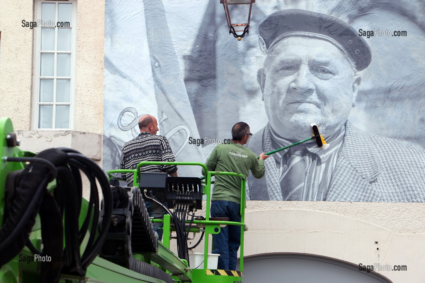 COLLAGE AVEC UNE NACELLE DES PHOTOS GEANTES SUR LES MURS DE LA VILLE POUR LE FESTIVAL CULTUREL RUGL'ART, RUGLES, (27) EURE, FRANCE 