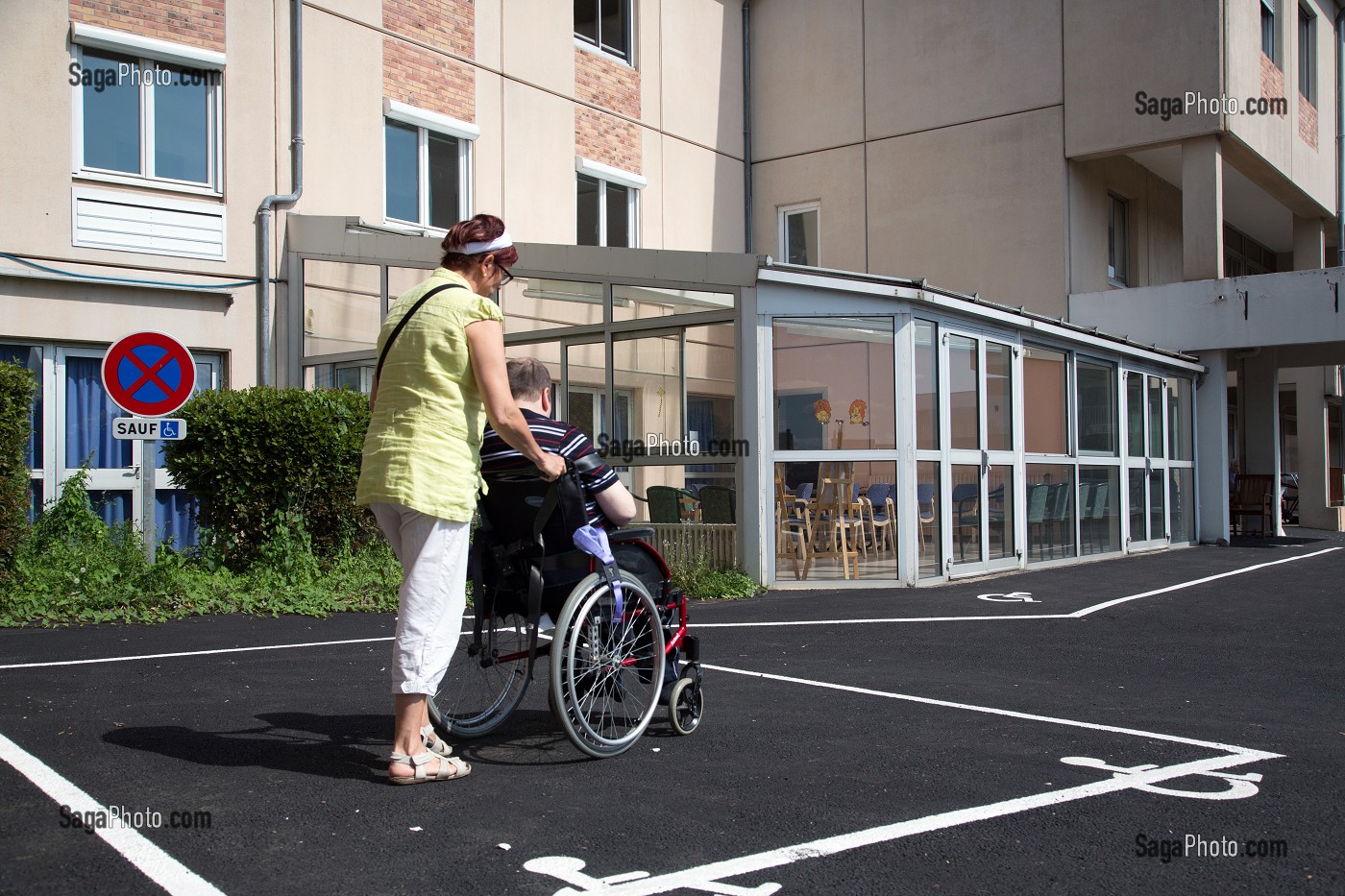 AIDE-SOIGNANTE POUSSANT LE FAUTEUIL ROULANT D'UN RESIDENT HANDICAPE, EHPAD ANDRE COUTURIER, ETABLISSEMENT PUBLIC DU SUD DE L'EURE, HEBERGEMENT POUR PERSONNES AGEES INDEPENDANTES, RUGLES, EURE (27), FRANCE 